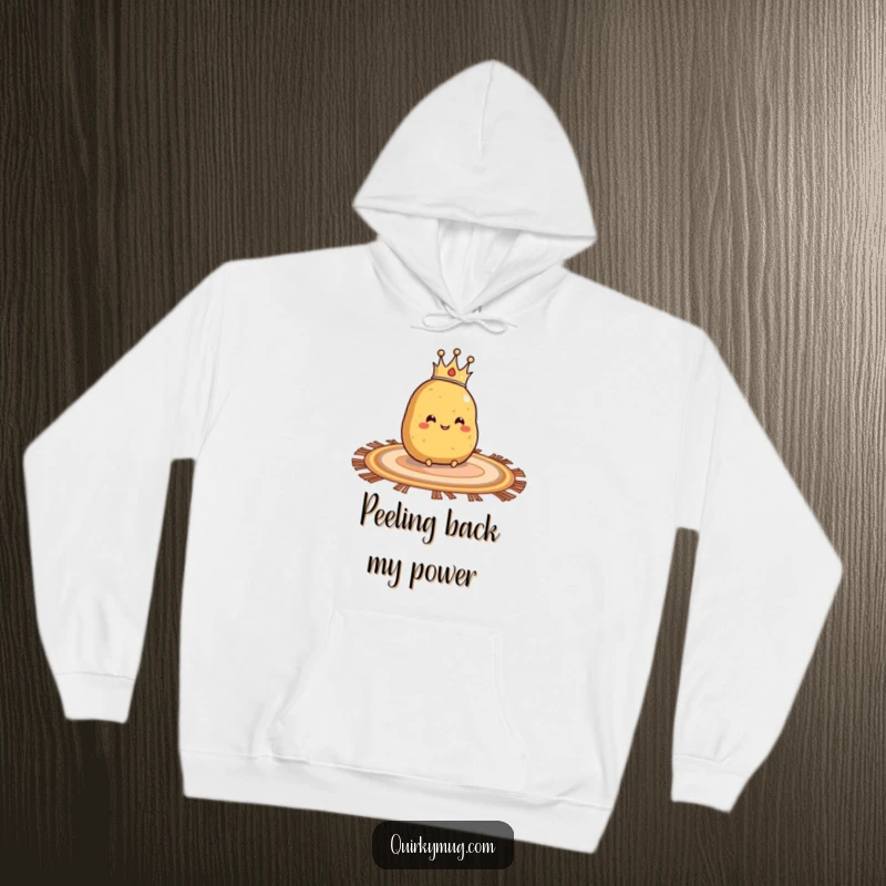 Funny hoodie showing a smiling potato with a crown, sliding comfortably on a rug.