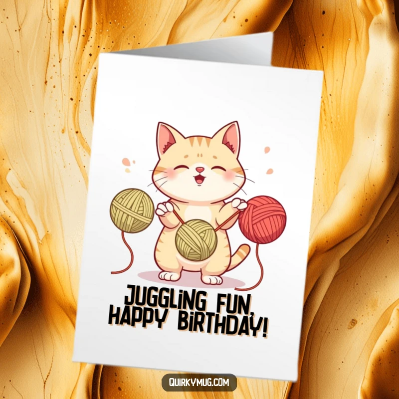 Funny Free Printable Birthday Card: Mischievous cat juggling three colorful yarn balls with a playful expression.