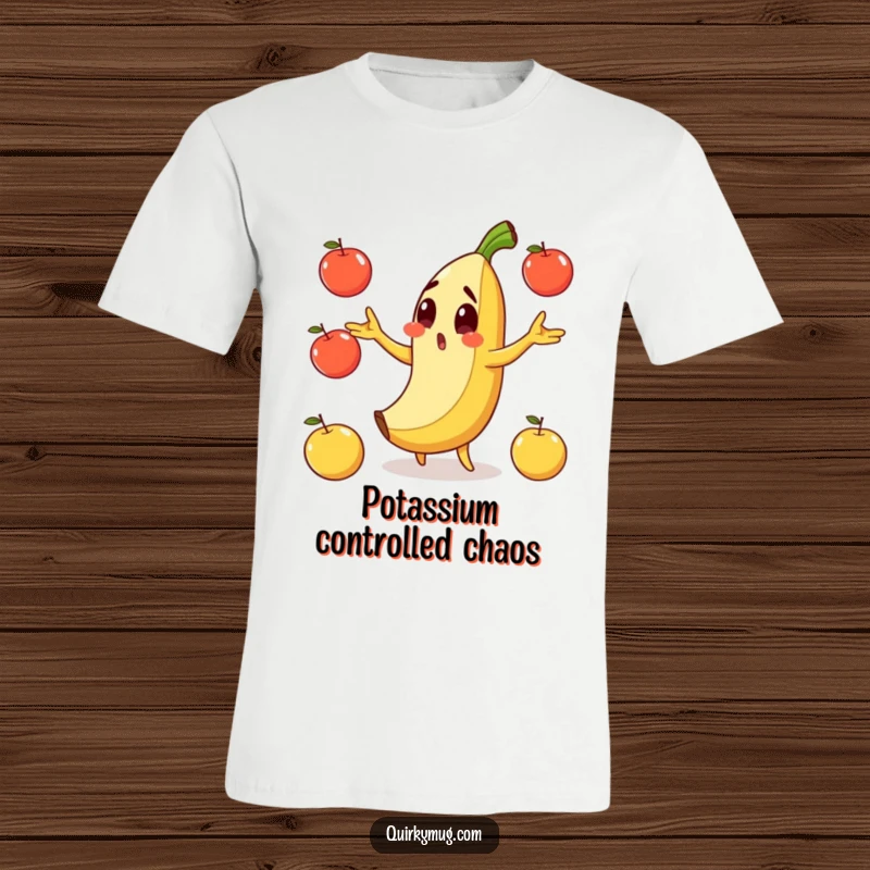 Funny t-shirt depicting a surprised banana character mid-fall on its peel, juggling apples precariously.